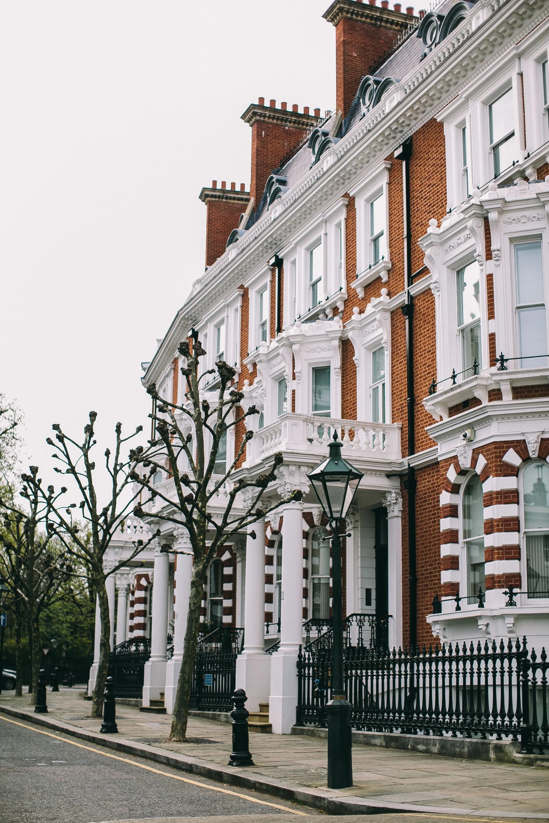 Red brick terraced houses with white window surrounds and roof details in London